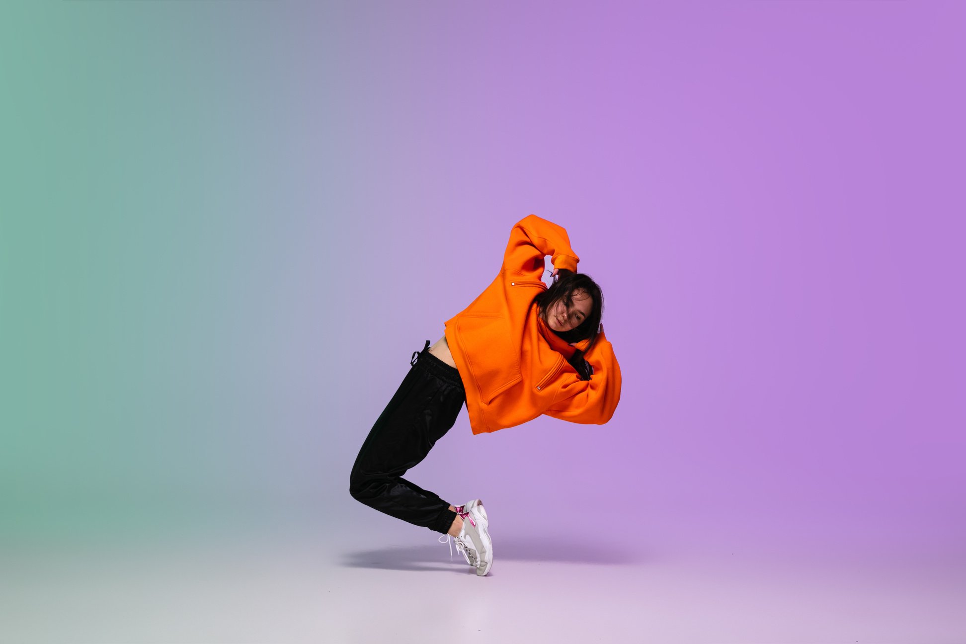 Girl Dancing Hip-Hop in Stylish Clothes on Gradient Background at Dance Hall in Neon Light.